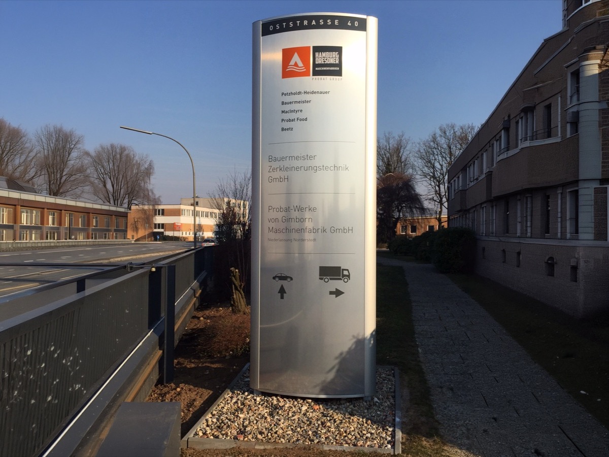 Beschriftete Firmen-Stele mit mehreren Unternehmensschildern im Außenbereich